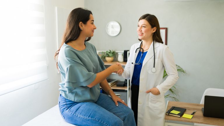 Female,Doctor,Happily,Shaking,Hands,With,Her,Hispanic,Patient,After