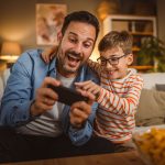 Father,And,Son,Sit,On,Sofa,And,Use,Mobile,Phone